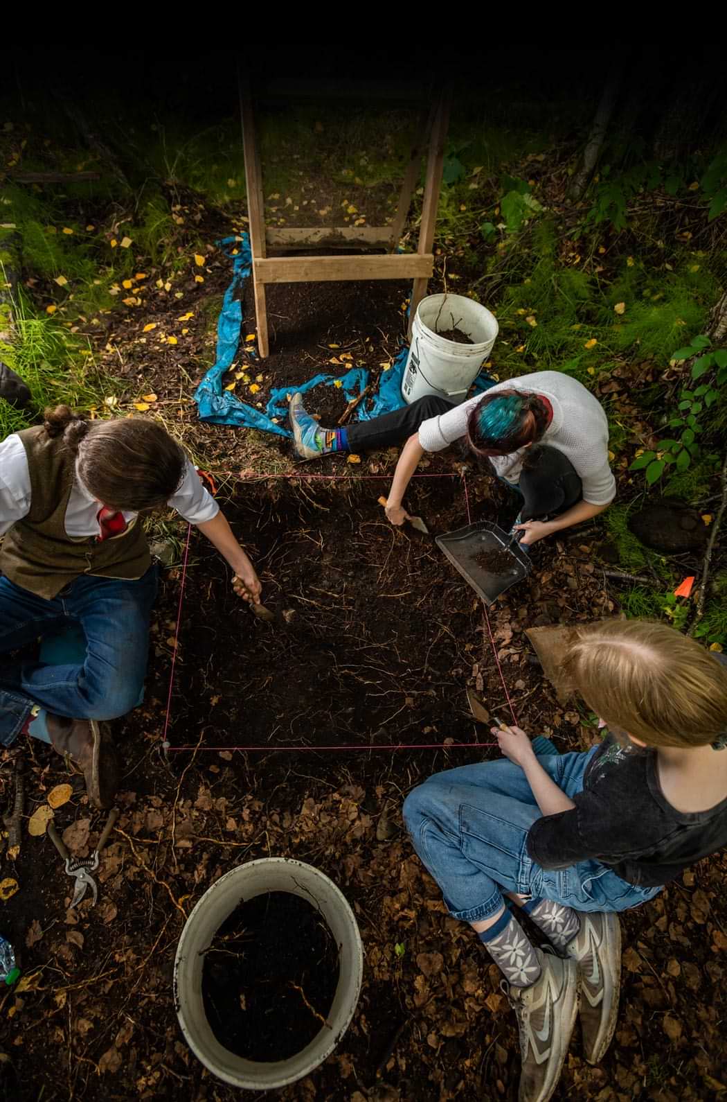 UAA anthropology students excavating in a forest