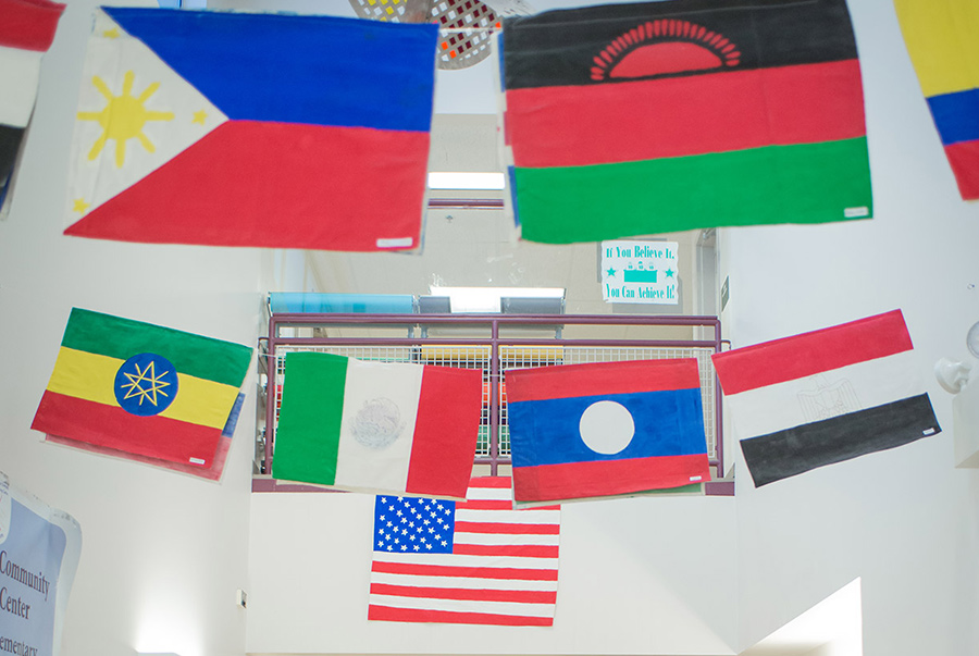 Many different flags of each country such as Philippines, Mexico, United States of America, etc. are held together by a string from one side of the wall to the other