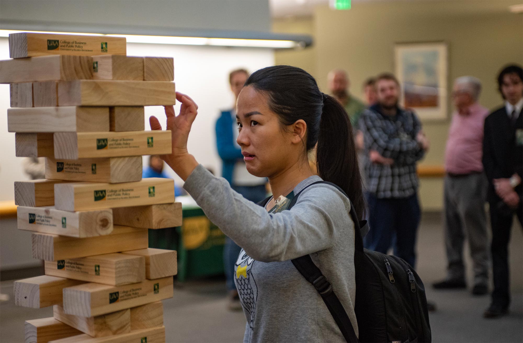 Lieu Dinh participates in a giant Jenga competition during a UAA College of Business and Public Policy event welcoming new students.