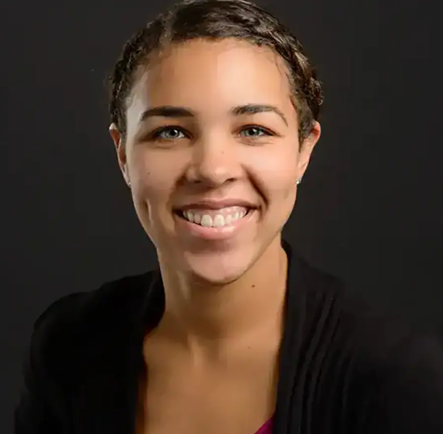 Headshot photograph of McKenzie Lallish smiling with a black business blazer suit