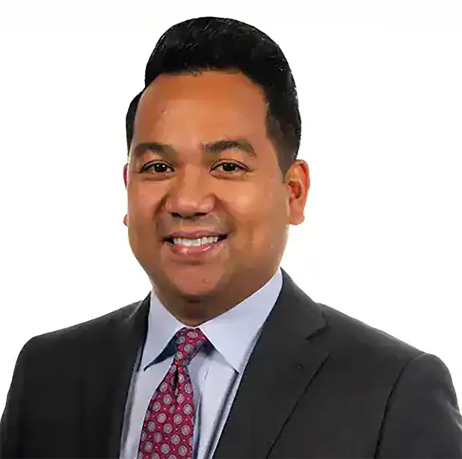 Headshot photograph of Dave Valdez smiling in a black business blazer suit