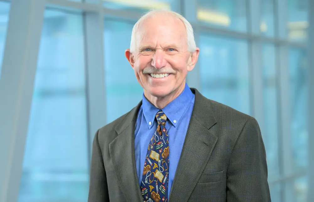 Dr. Jay Butler, University of Alaska Anchorage (UAA) Dean of the College of Health, smiles in a charcoal grey business blazer suit